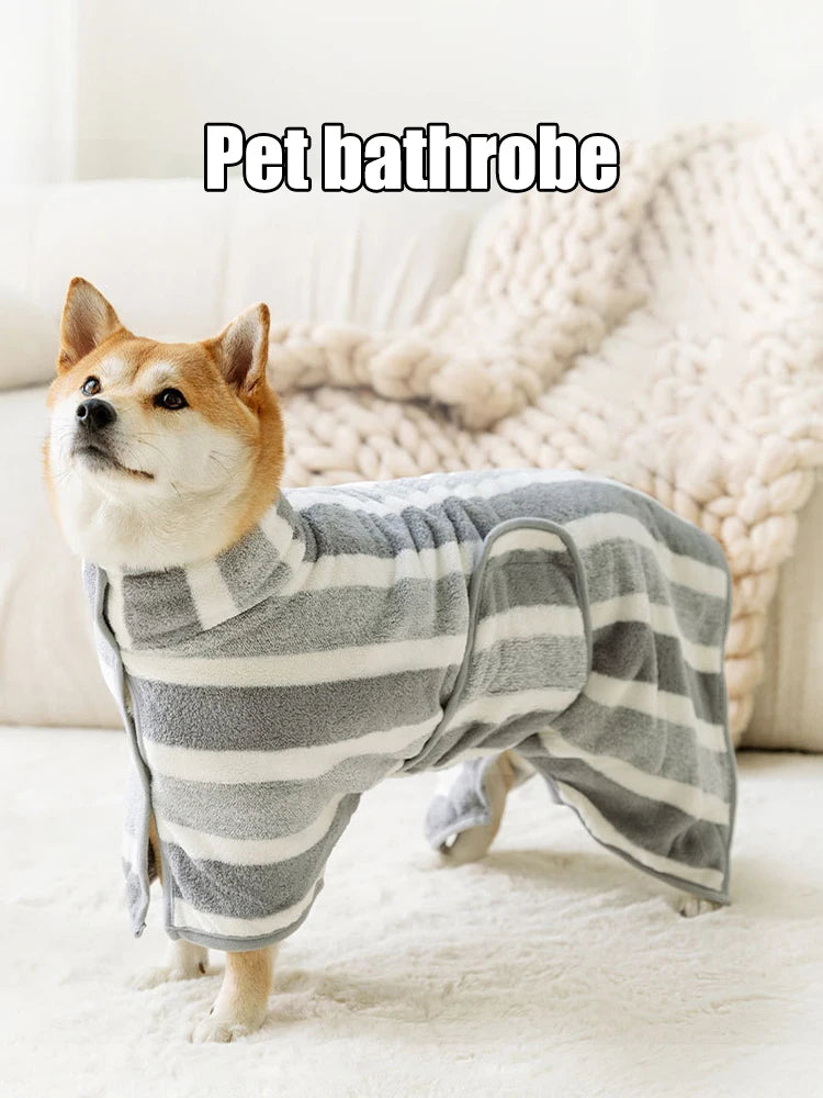 Dog wearing a gray and white striped pet bathrobe on a white couch.