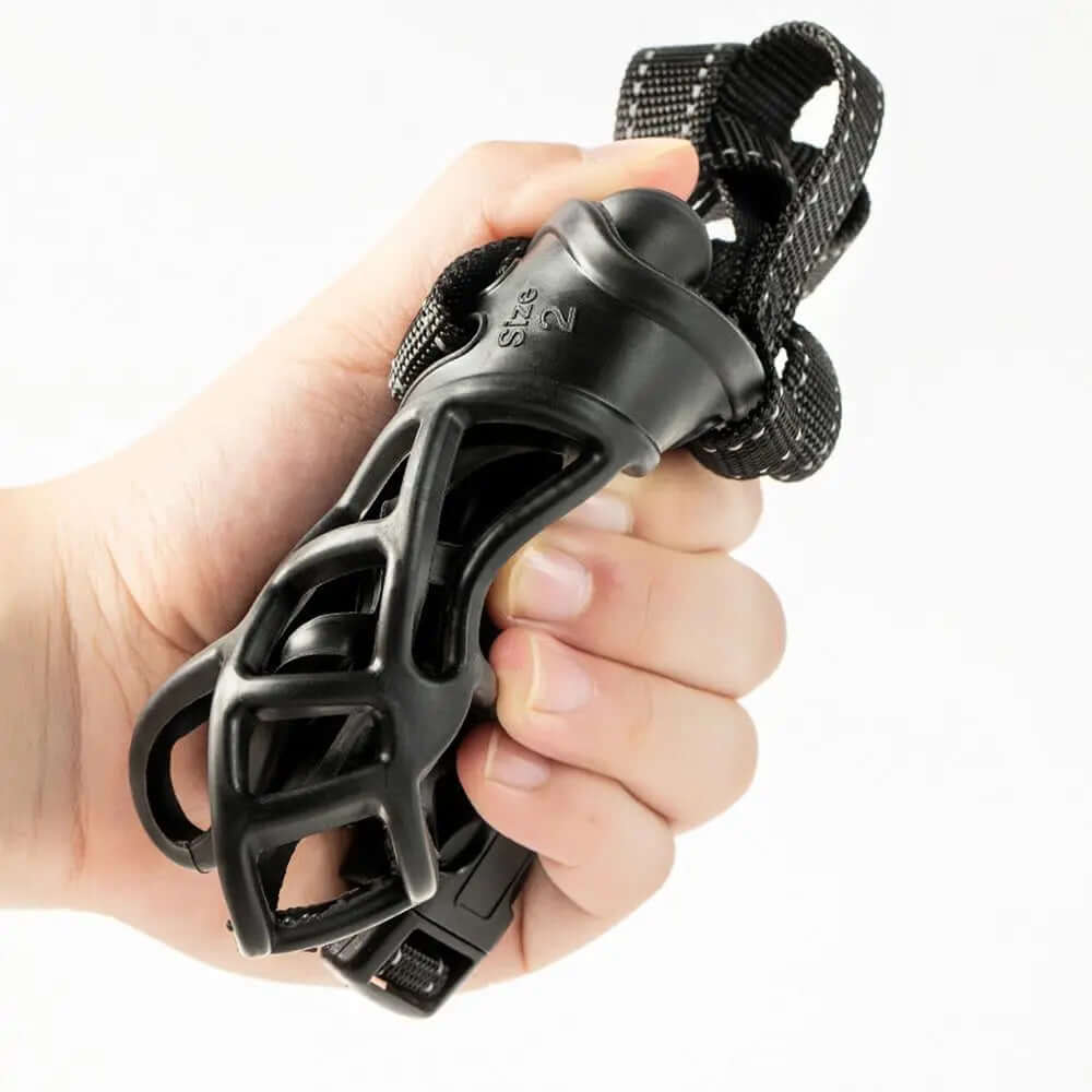 Black hand exerciser held in a hand against a white background
