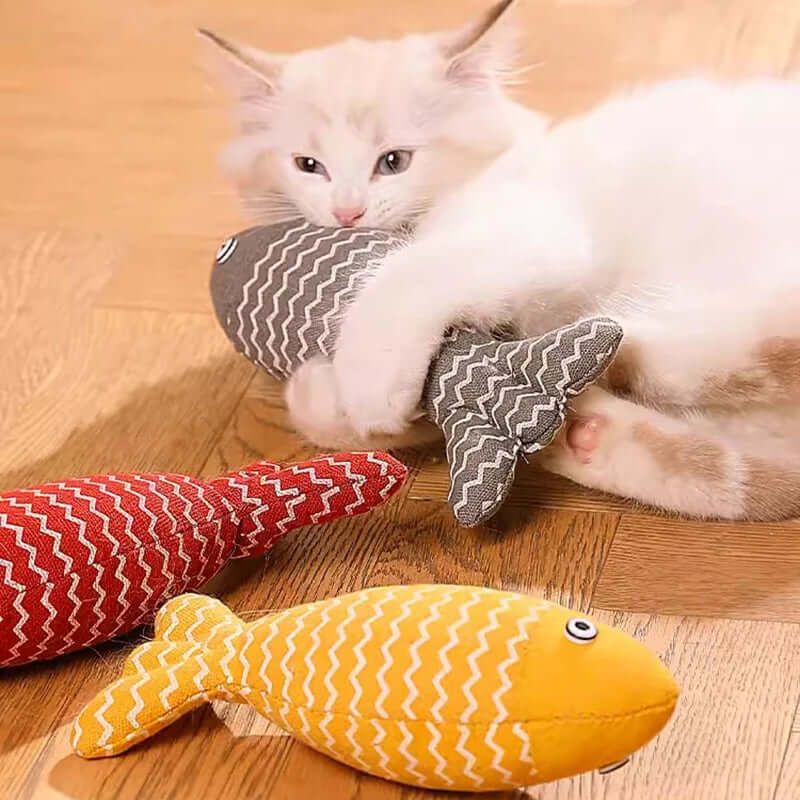 White cat playing with a red and gray striped toy on a wooden floor.