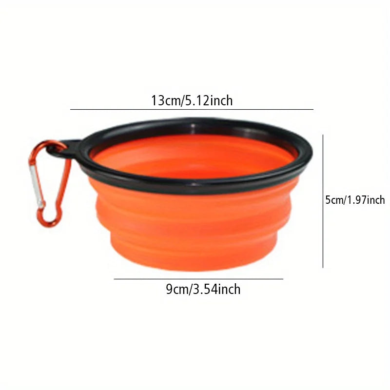 Orange collapsible travel bowl with black rim and red carabiner on a white background