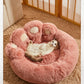 Fluffy pink pet bed with a cat inside on a carpeted floor.