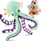 Green and purple octopus-shaped dog toy with a dog playing with it.