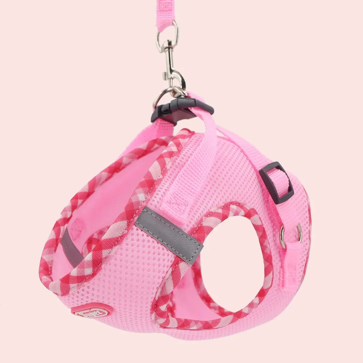 Pink dog harness with camouflage pattern on a light pink background