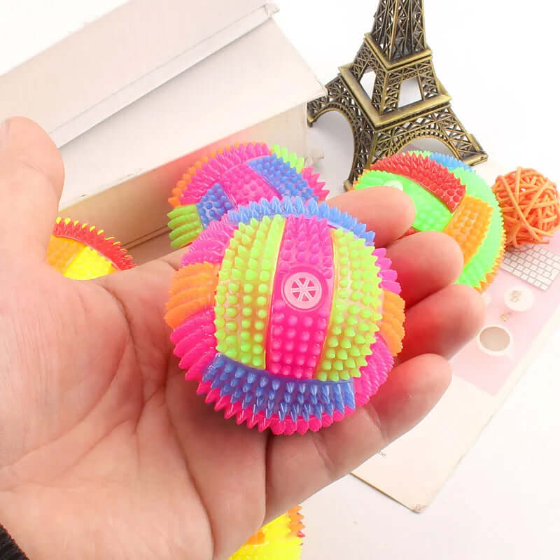 Colorful textured ball held in a hand with a blurred background