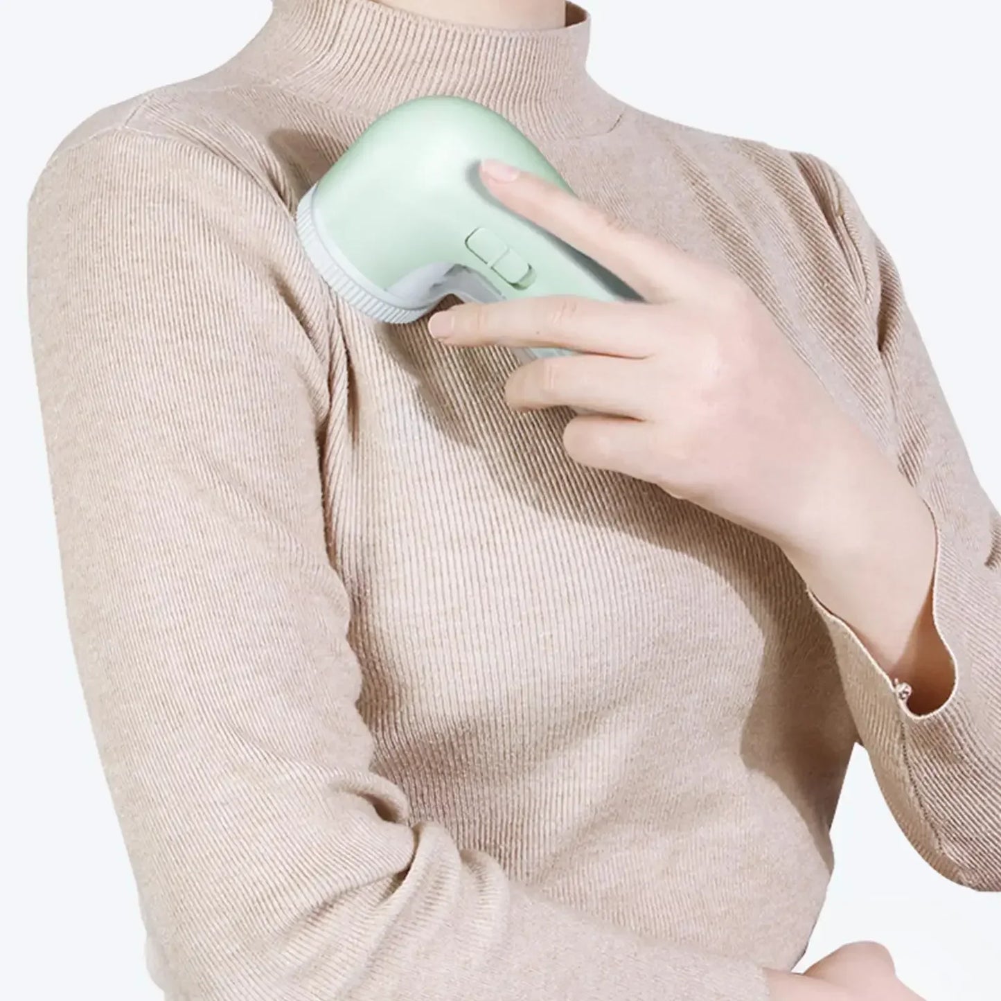 Person wearing a beige sweater holding a light green handheld device against their chest.