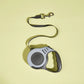 Retractable dog leash with gray handle on a yellow background