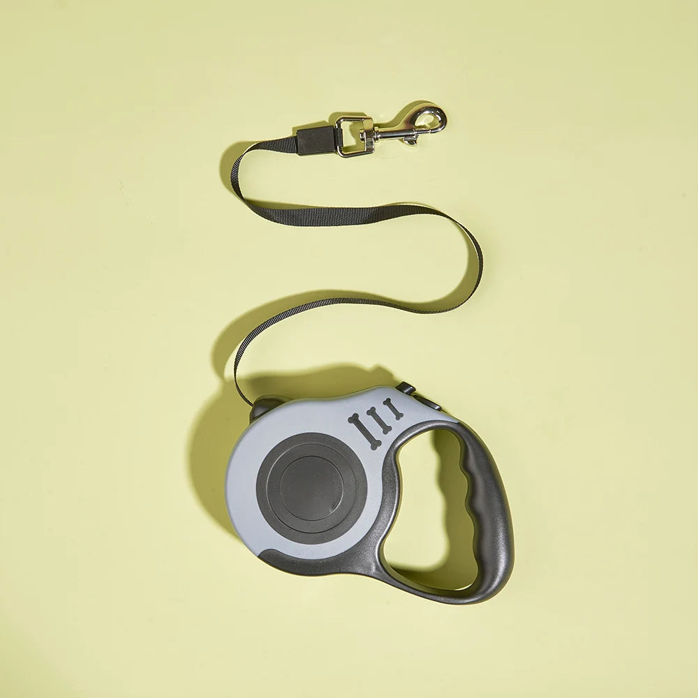 Retractable dog leash with gray handle on a yellow background