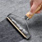 Hand holding a glass cleaning tool on a gray surface