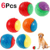 Set of six colorful dog toys with a dog sitting next to them.
