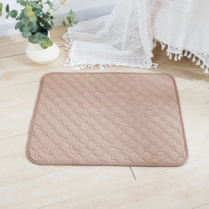 Quilted beige mat on a light wooden floor with a plant and white lace fabric in the background.