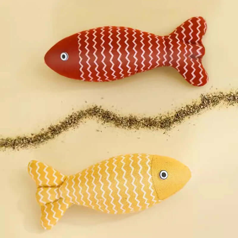 Two fish-shaped toys, one red and one yellow, on a beige background.