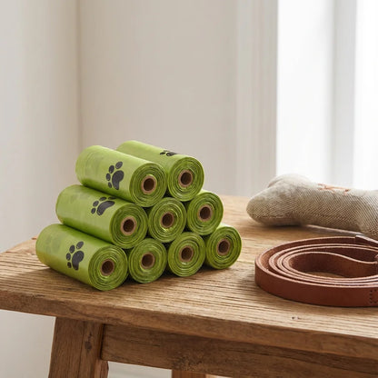 Stack of green pet waste bags on a wooden table with a beige curtain background