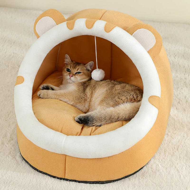 Cat lying on a round, beige pet bed with white rim and cat ears on a beige carpet.