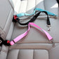 Two dog seat belts, one pink and one black with a blue handle, on a car seat.