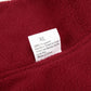 Close-up of a red fabric with a label indicating size XL and care instructions.
