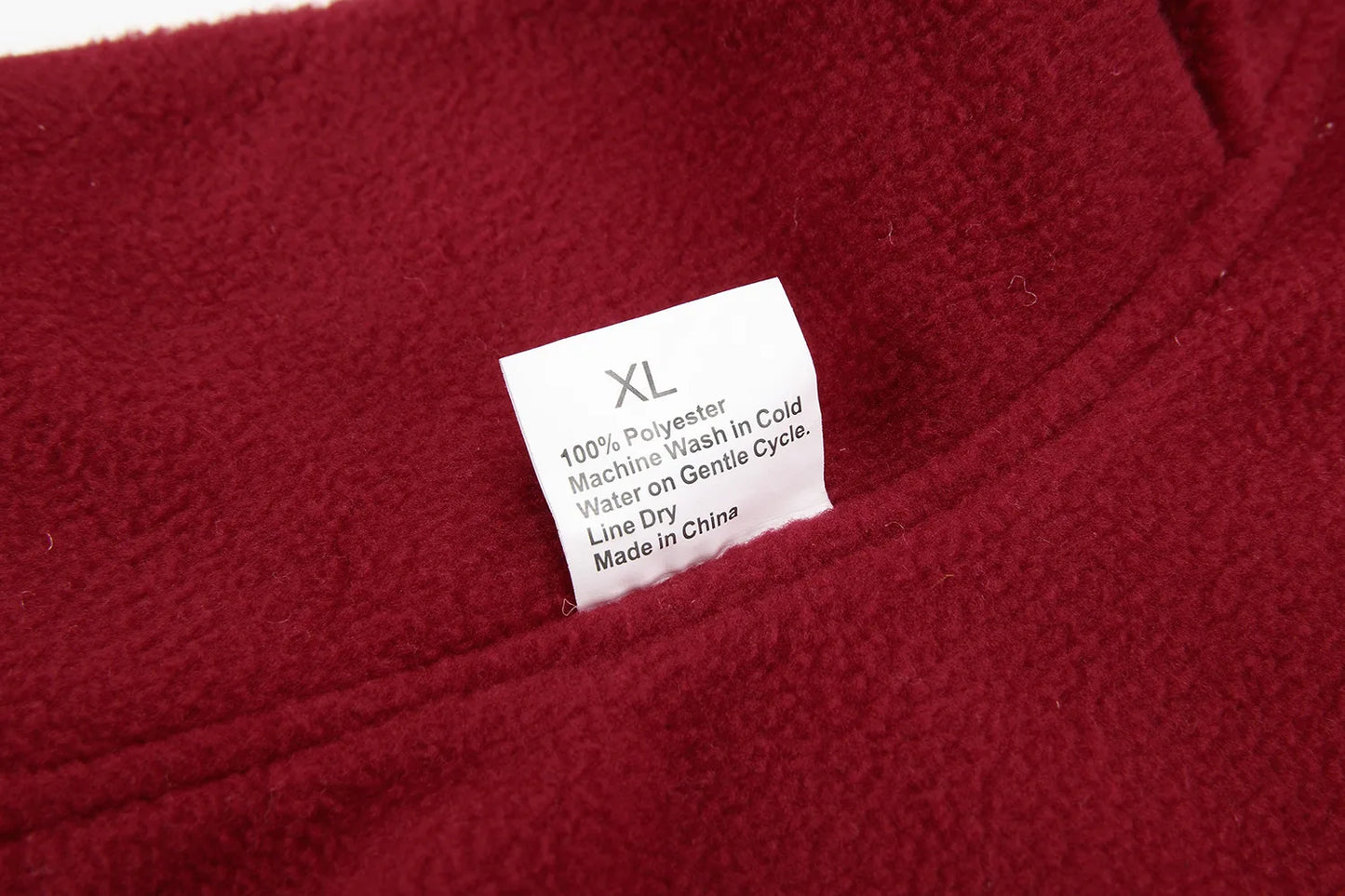 Close-up of a red fabric with a label indicating size XL and care instructions.