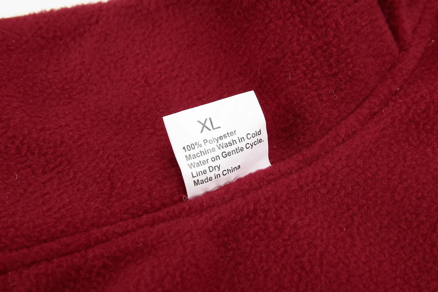 Close-up of a red fabric with a label indicating size XL and care instructions.