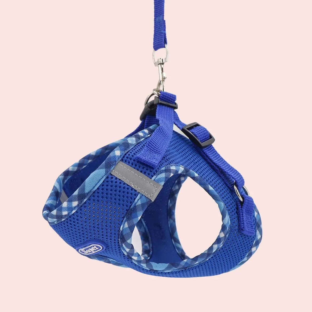 Blue dog harness with a checkered pattern on a pink background
