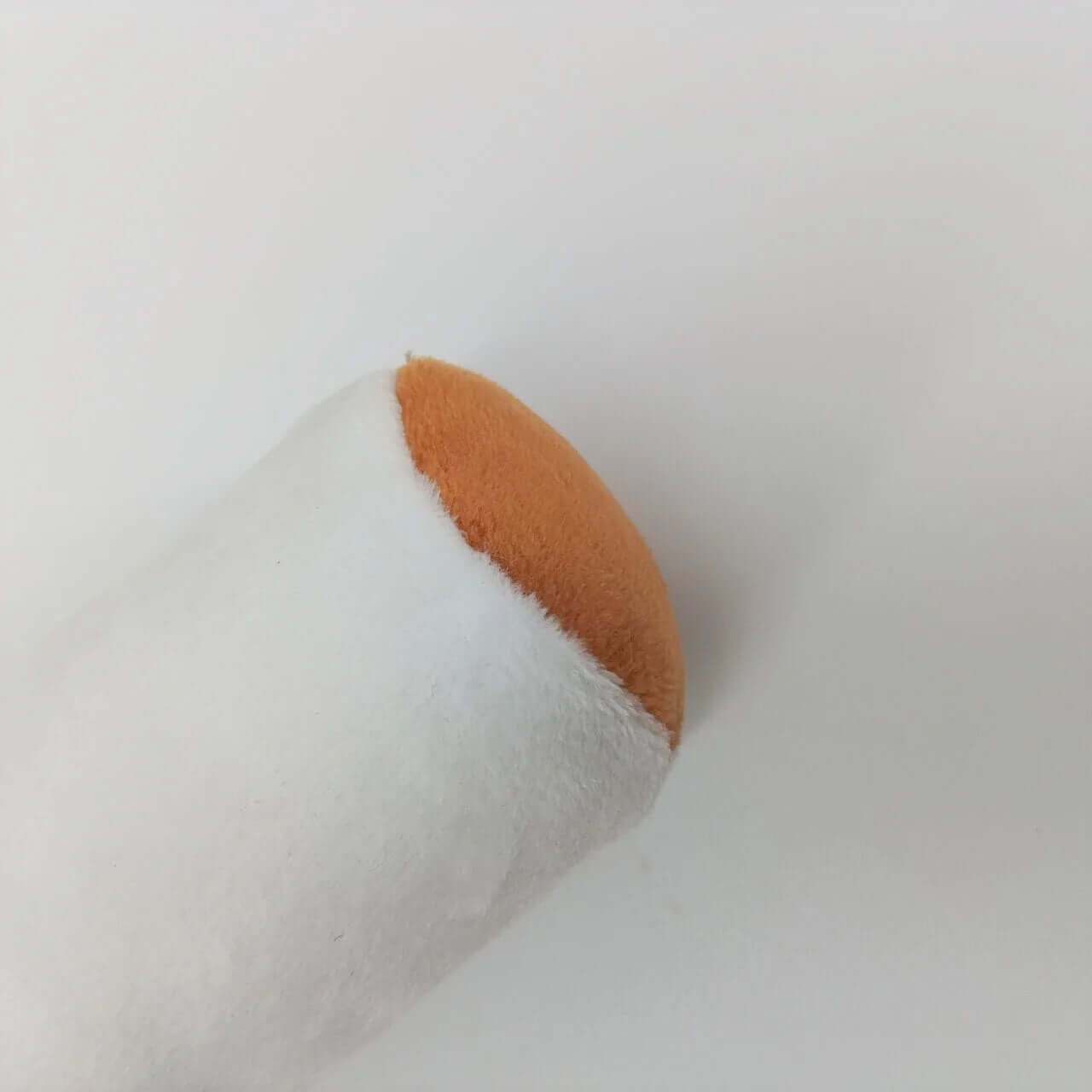 White makeup sponge with brown tip on a light gray background