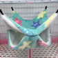Pet hammock with starfish design hanging inside a cage