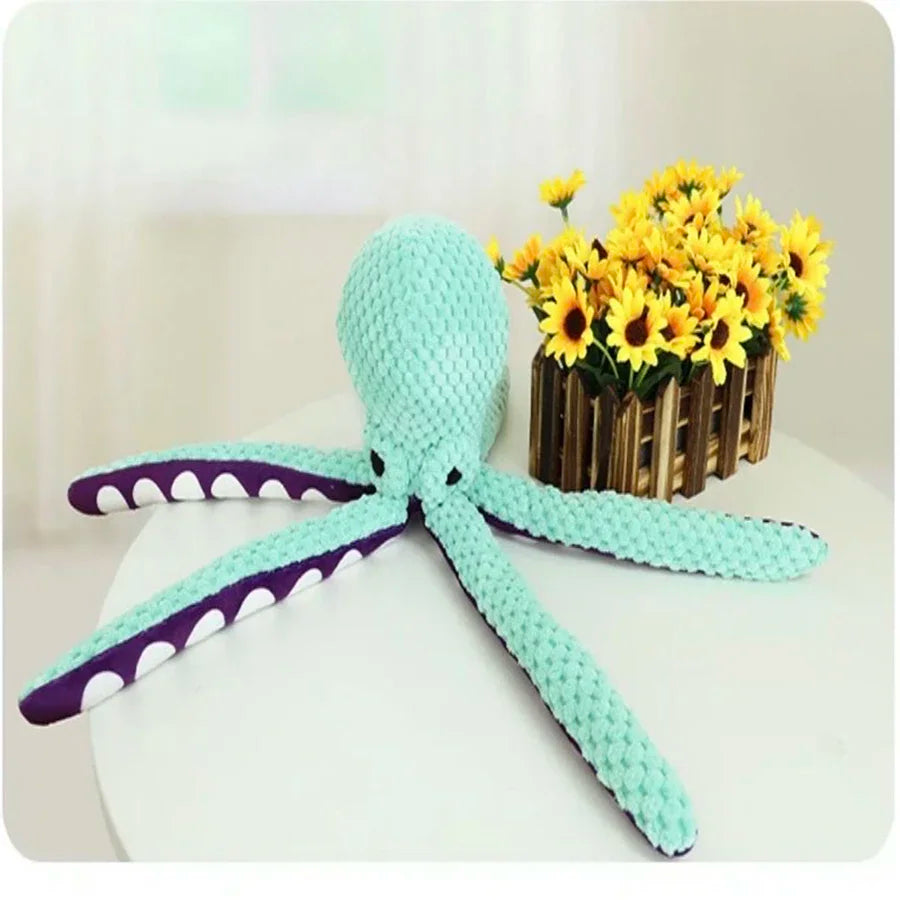 Knitted octopus toy with yellow sunflowers in a wooden basket on a white surface