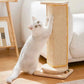 White cat playing with a wooden scratching post on a wooden floor.