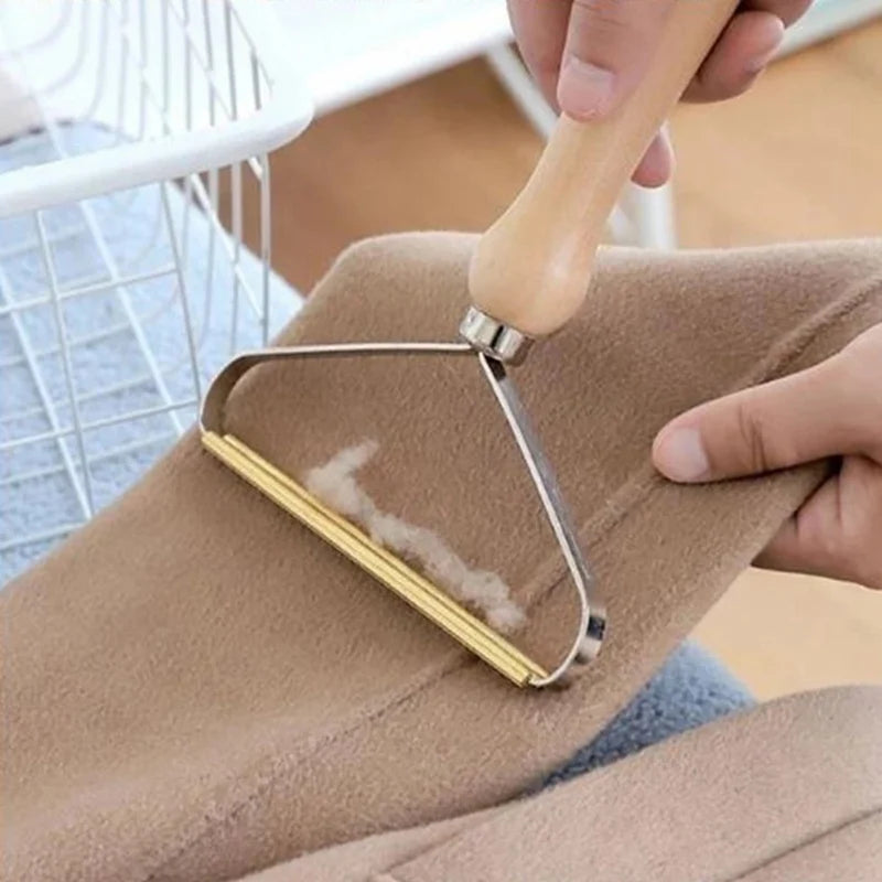 Person using a fabric roller on a piece of clothing with a blurred indoor background