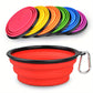 Collapsible silicone dog bowl with carabiner in red, surrounded by colorful lids on a white background