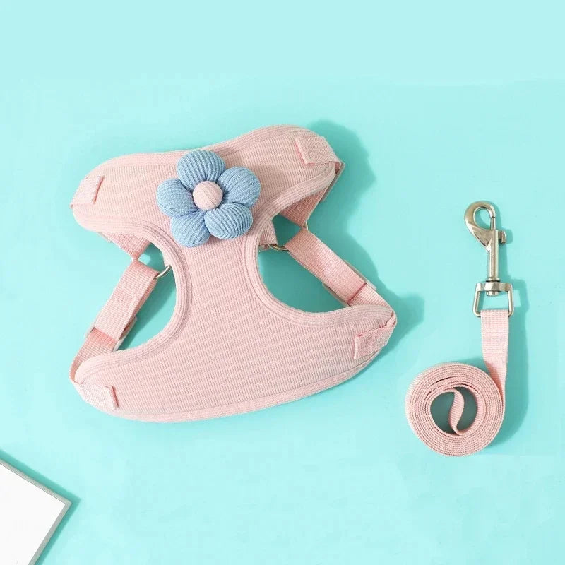 Pink pet harness with blue flower and matching leash on a light blue background