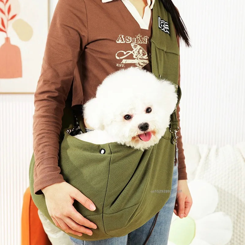 Person carrying a small white dog in a green sling bag.