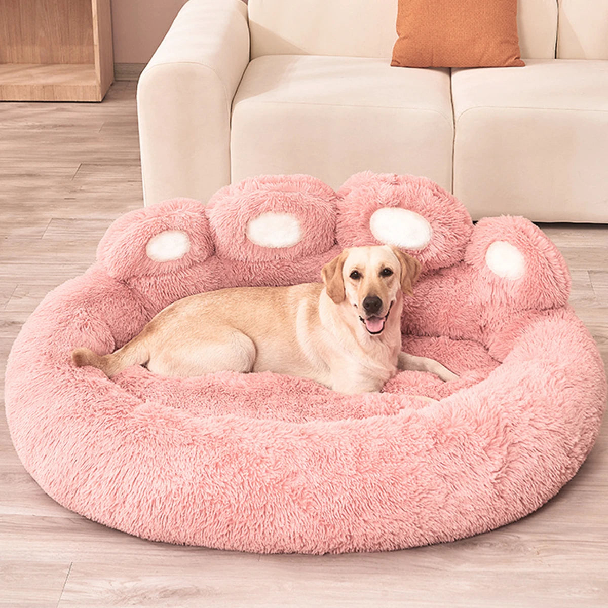 Dog lying on a pink paw-shaped pet bed in a living room.