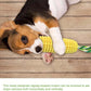 Dog playing with a corn-shaped chew toy on a wooden floor