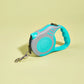 Turquoise and gray retractable dog leash on a light yellow background