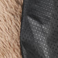 Close-up of black textured fabric on a fluffy beige surface