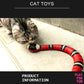 Cat playing with a red and black toy snake on a tiled floor.