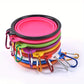 Set of colorful silicone dog bowls with carabiners on a white background