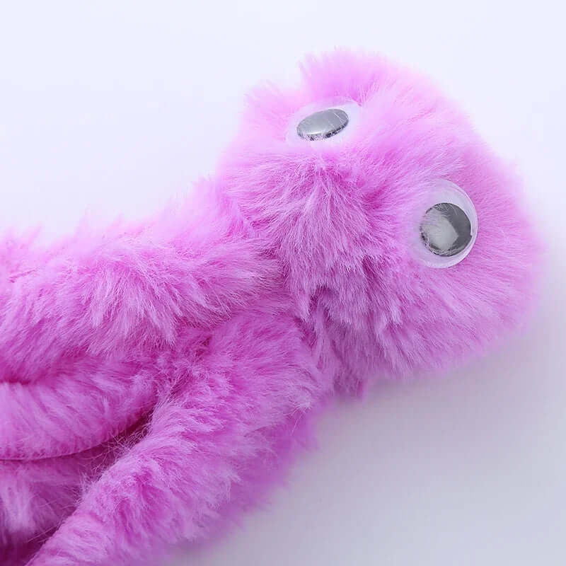 Close-up of a pink plush toy with googly eyes on a white background