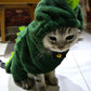 Cat wearing a green dinosaur costume indoors