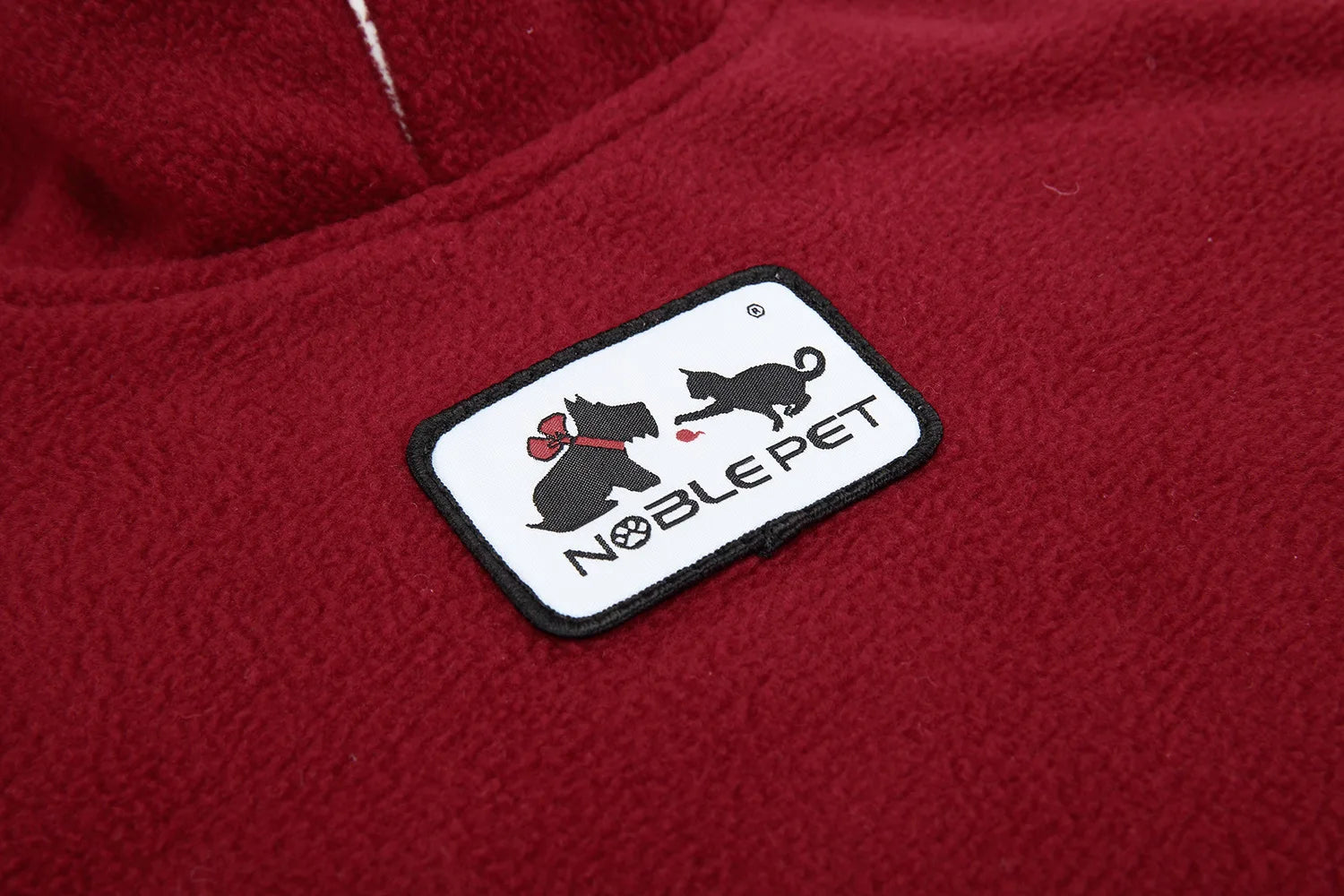 Noble Pet logo on a red fabric background