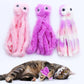 Three plush toy octopuses in pink, purple, and gradient colors with a cat interacting with one of them on a white background.