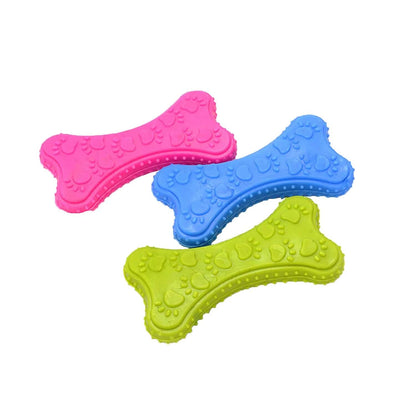 Three bone-shaped dog toys in pink, blue, and green on a white background