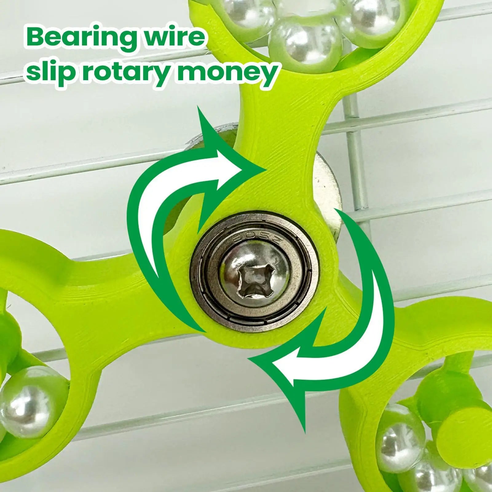 Green fidget spinner with metallic bearing and text 'Bearing wire slip rotary money' on a white background.
