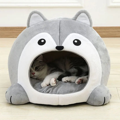 Gray pet bed shaped like a cartoon character with a cat inside on a wooden floor.
