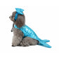 Dog wearing a blue mermaid costume with a tail and headpiece on a white background
